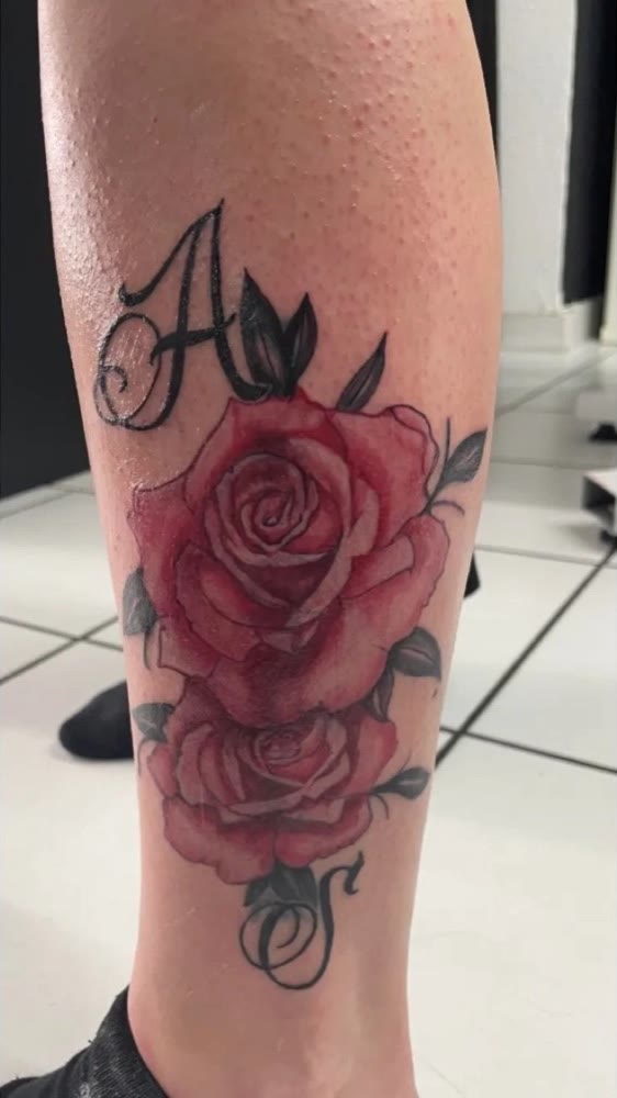 Rote Rosen mit Buchstabe A an der Wade